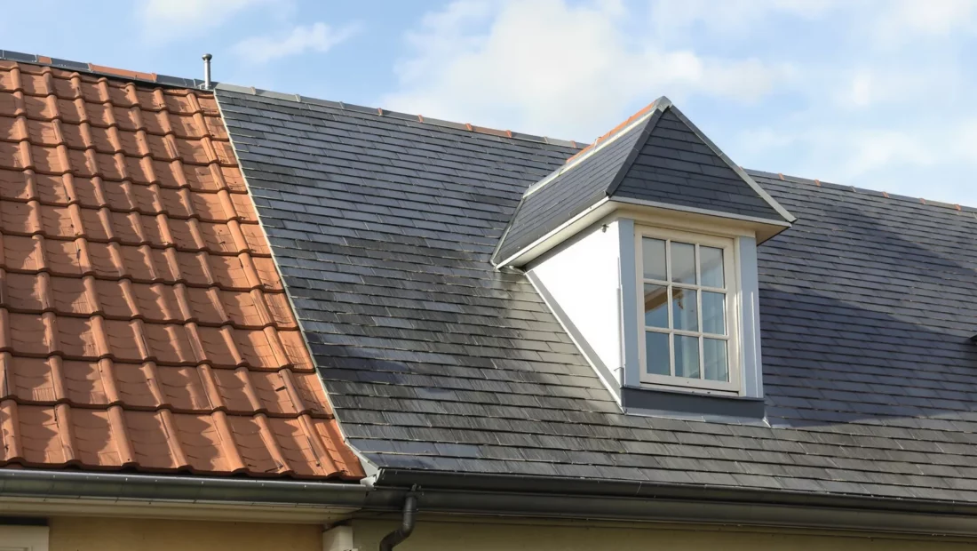 Toiture de maison avec ardoises naturelles, tuiles en terre cuite et lucarne en zinc