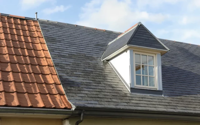 Toiture de maison avec ardoises naturelles, tuiles en terre cuite et lucarne en zinc