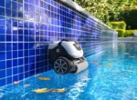 Robot de piscine sans fil qui grimpe la paroi carrelée d'une piscine enterrée à l'automne