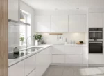 Cuisine équipée moderne aux façades blanches et chêne clair avec plan de travail en quartz